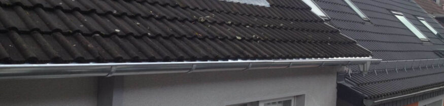 Dachrinnen am Mehrfamilienhaus werden gereinigt